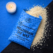 Bag of American Soy Organics Millennium Soy Wax with a candle on a blue and black background